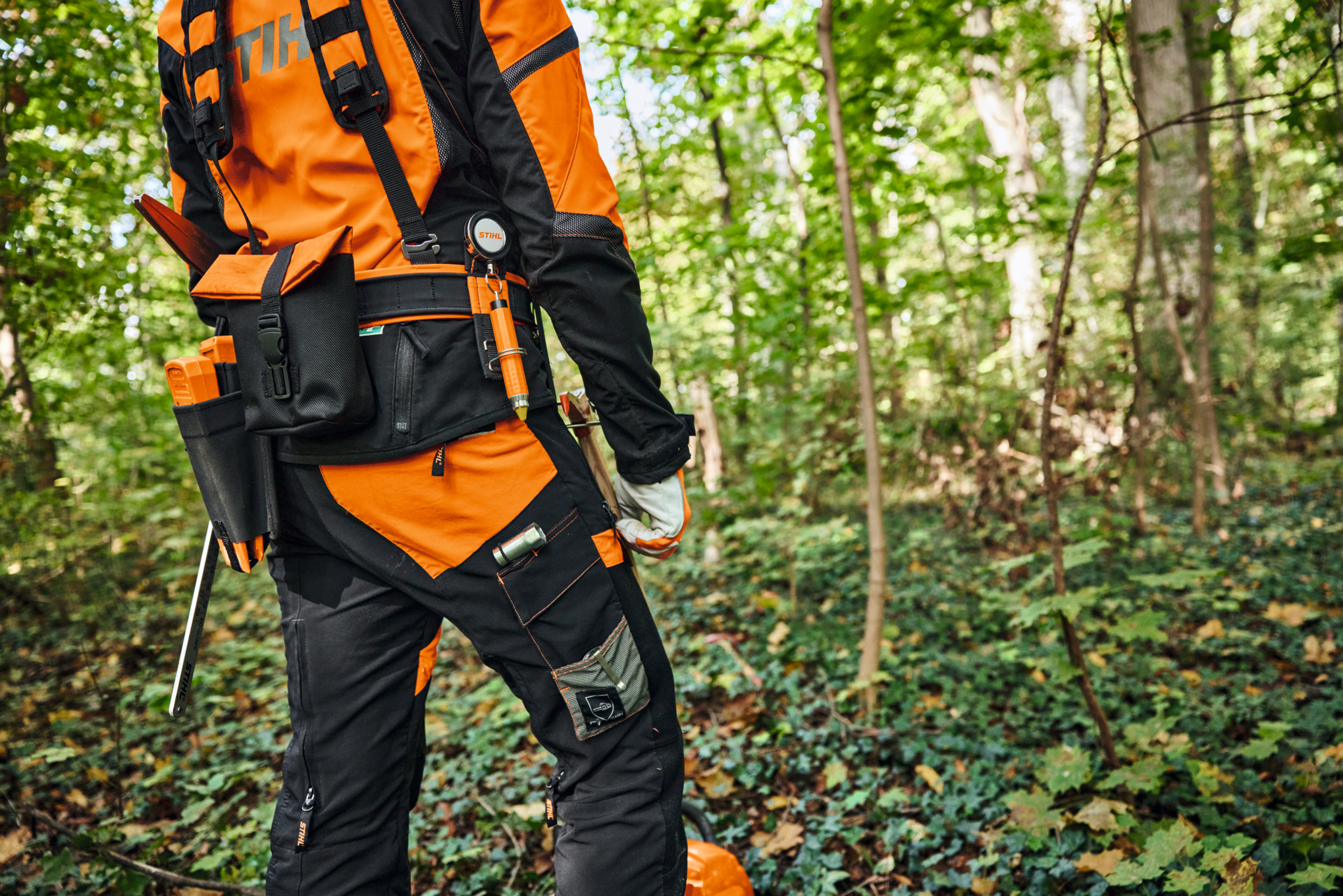 Osoba w sprzęcie ochronnym i modułowym systemie nośnym STIHL ADVANCE X-Flex w lesie